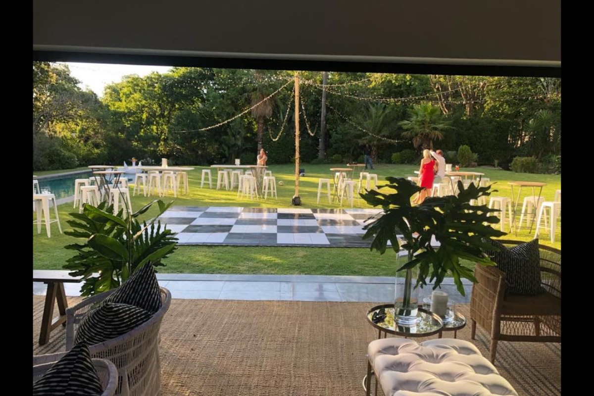 Outdoor event layout with cocktail tables and checkerboard dance floor