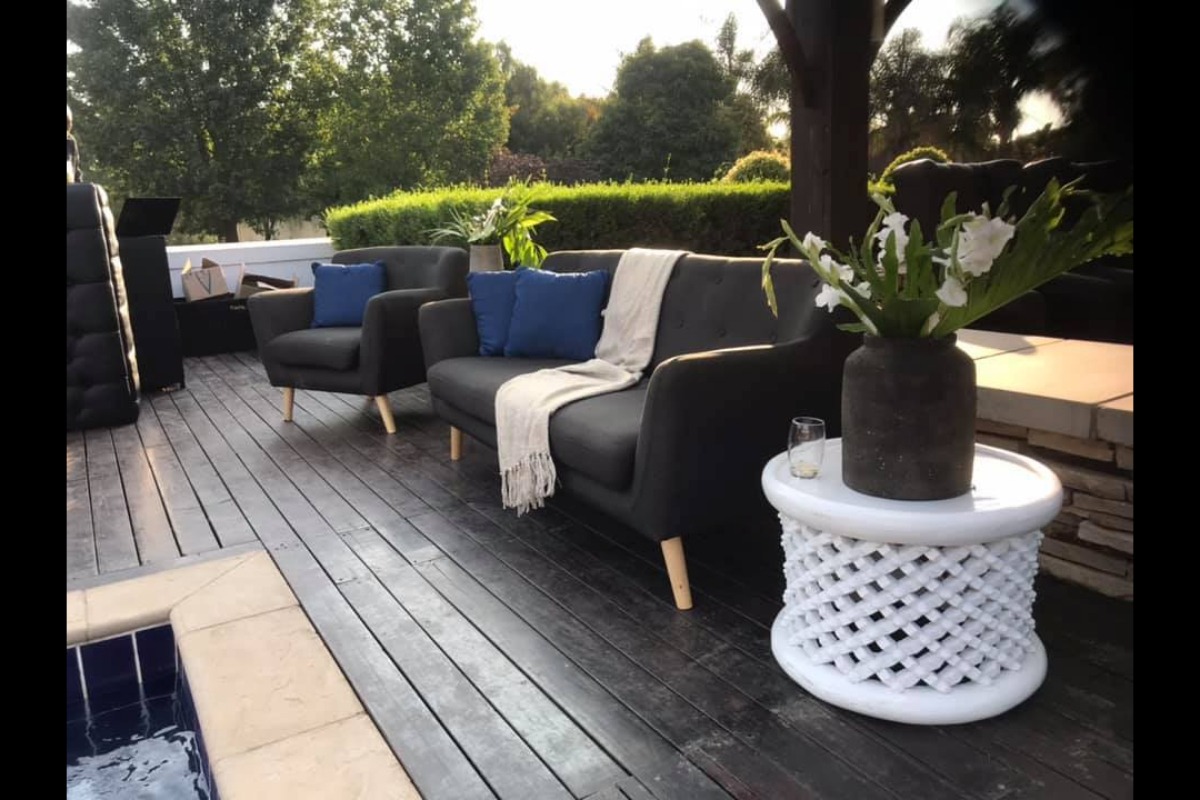 Black outdoor seating with blue cushions and floral arrangement
