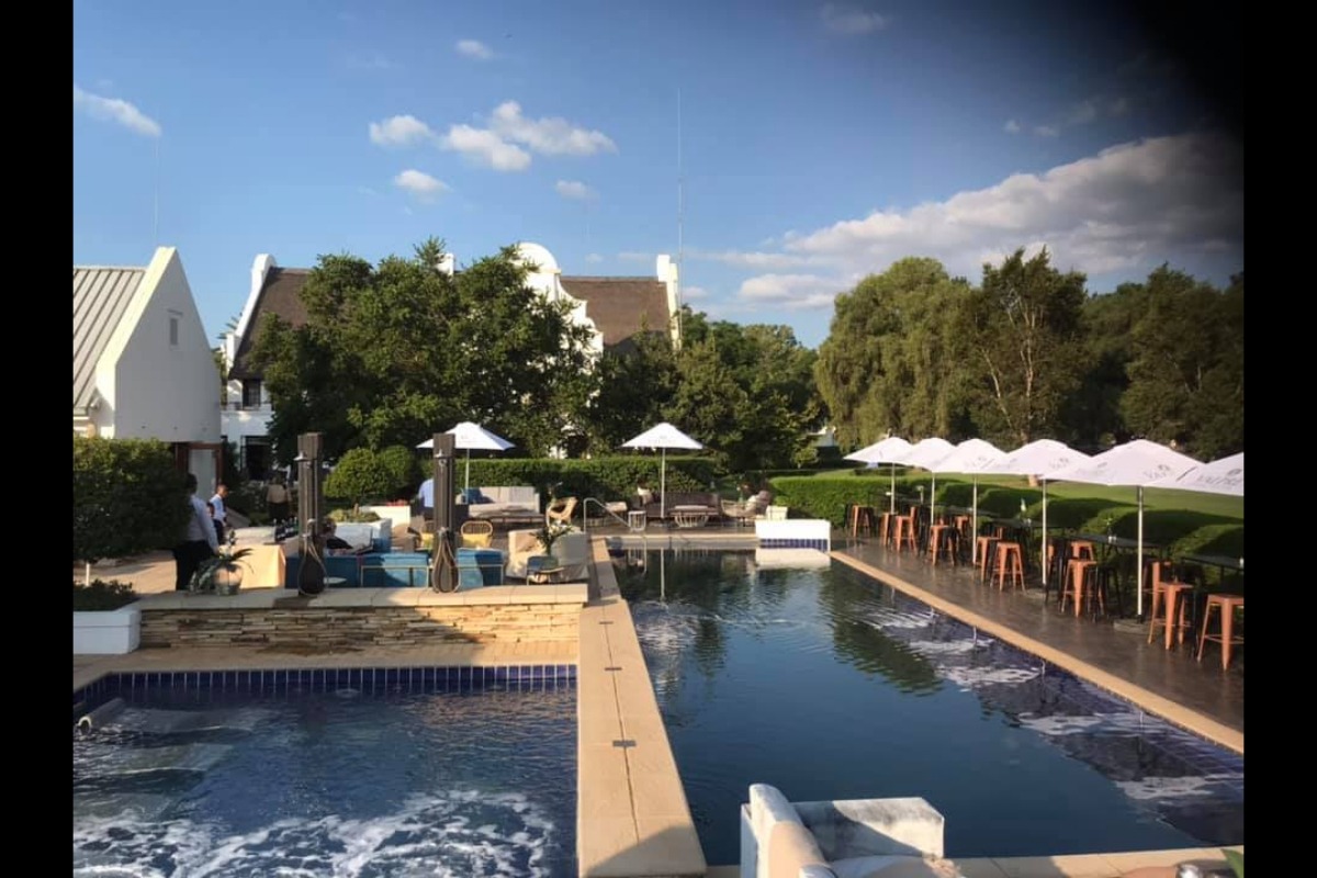 Poolside event furniture with umbrellas and bar setup – Cape Town event hire