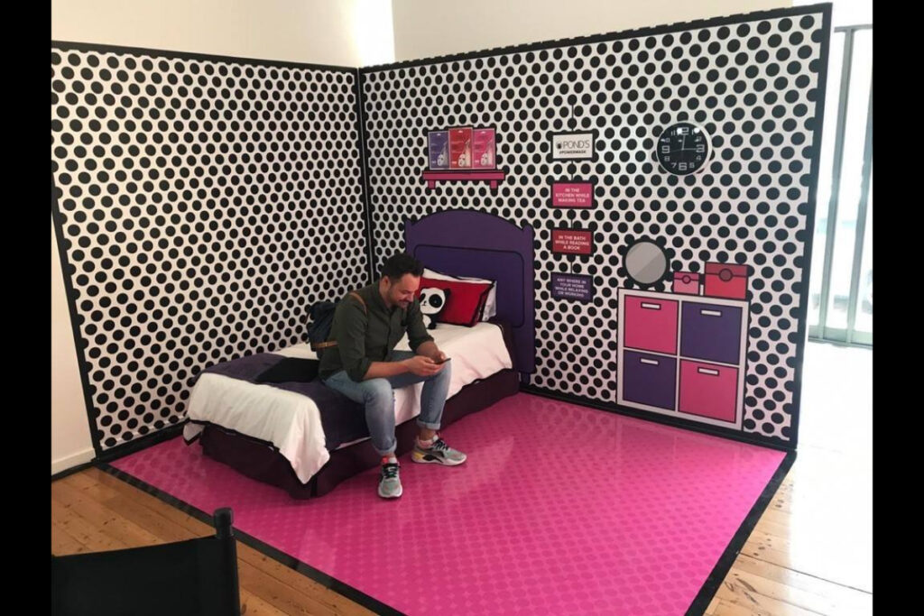 Playful kids bedroom-inspired expo booth design in pink and black