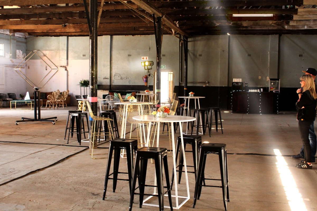 Industrial venue with high tables and stools for event styling in Cape Town