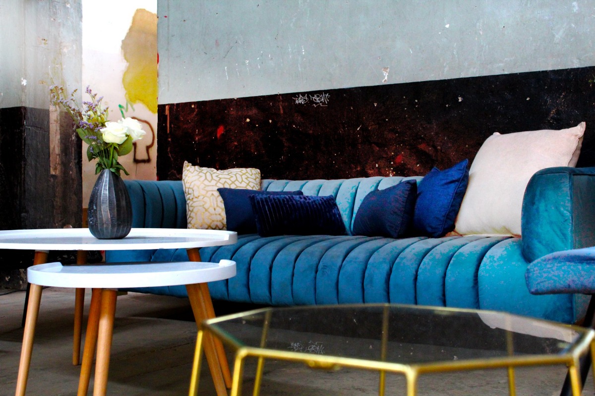 Modern blue velvet couch with decorative pillows – styled lounge setup for corporate events and brand activations