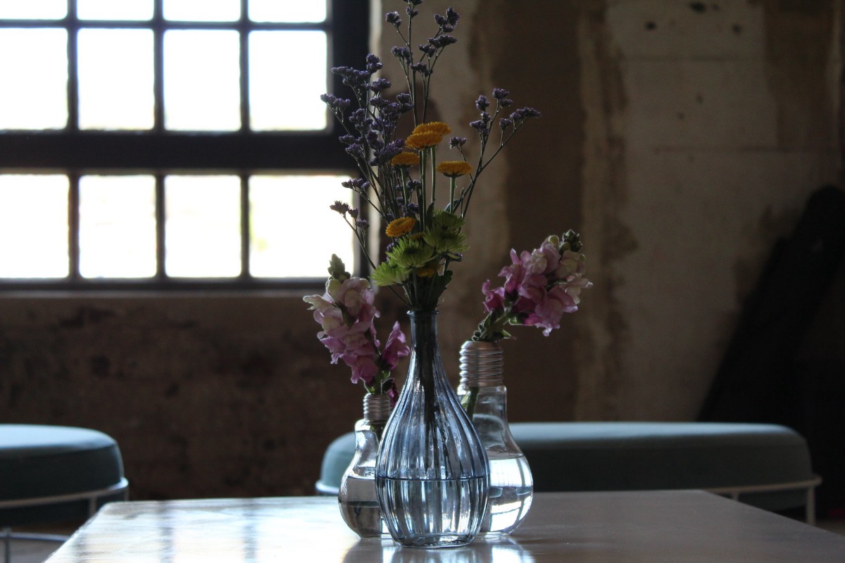Floral vase setup in front of moody window