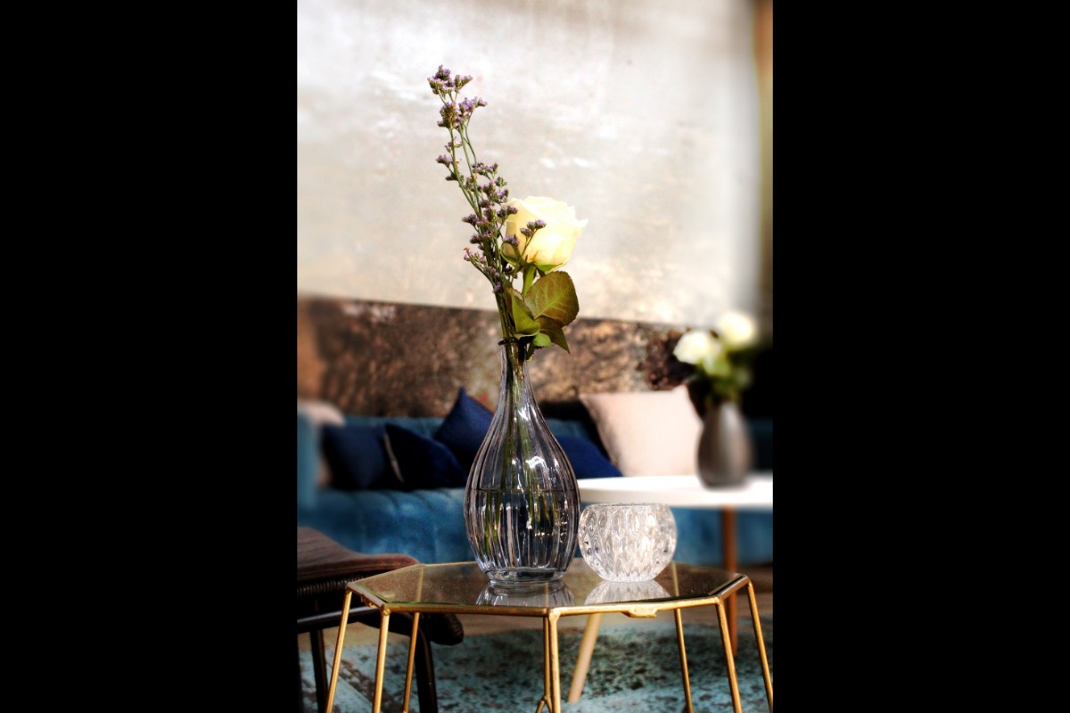 Vase arrangement next to velvet couch