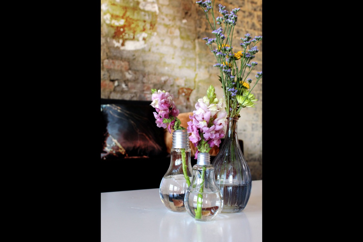 Decorative floral vases in front of rustic brick wall
