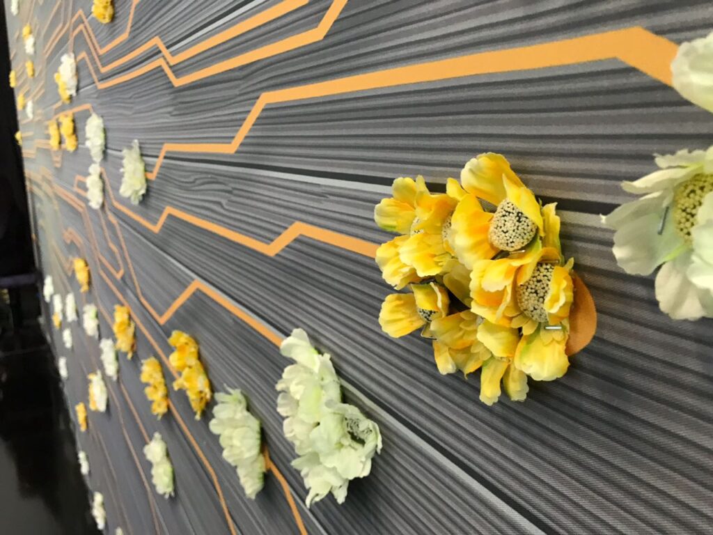 Custom flower feature wall with black background and orange blooms