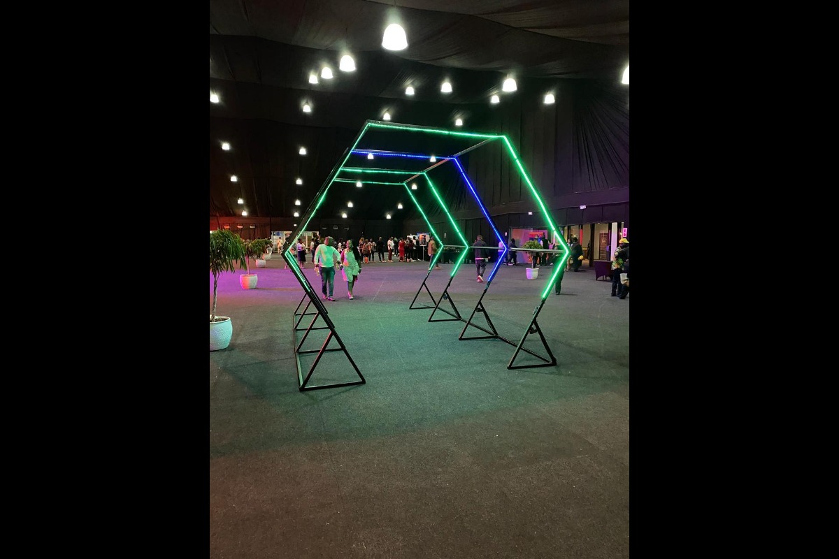 Green neon tunnel with floral lounge elements