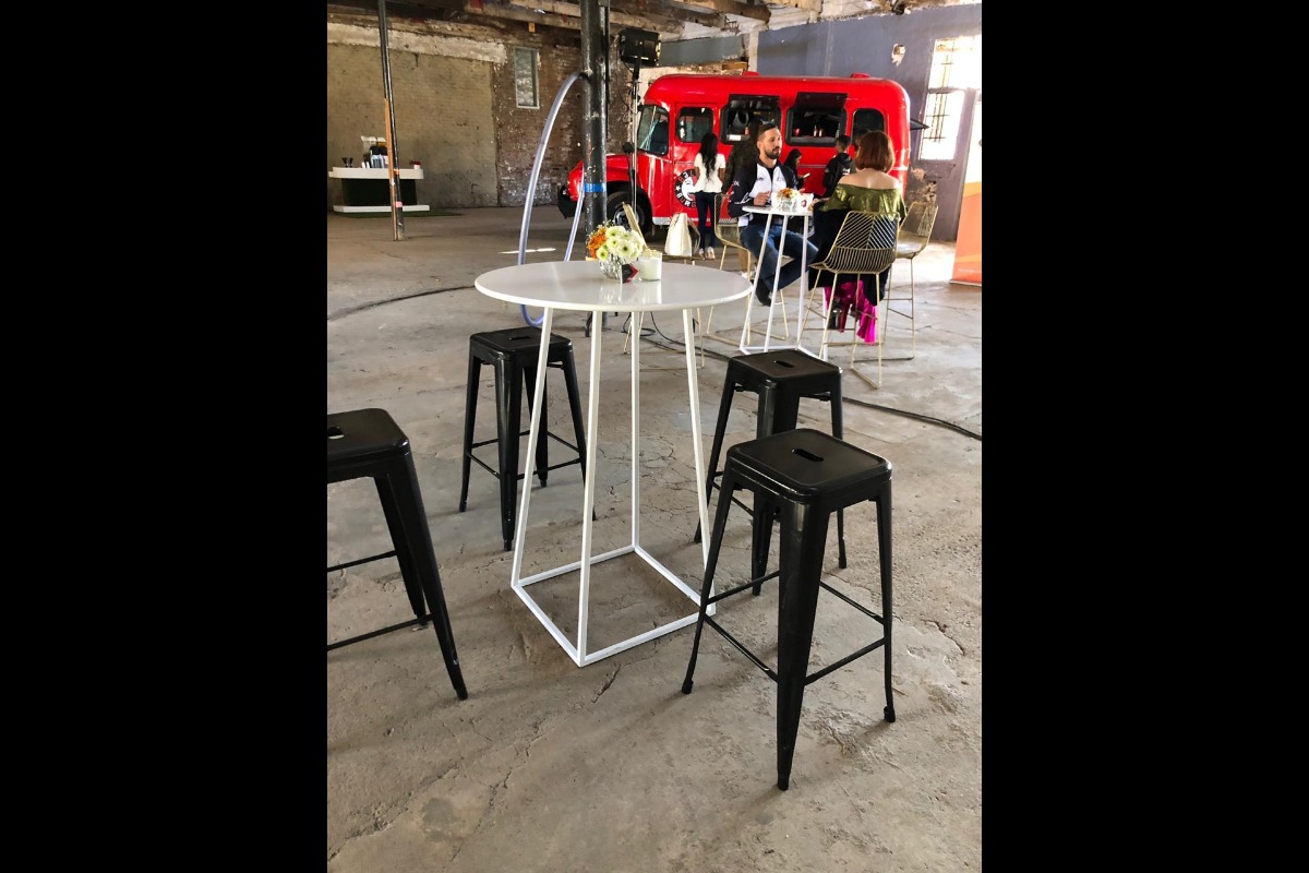 White bar tables and black bar stools at outdoor activation setup
