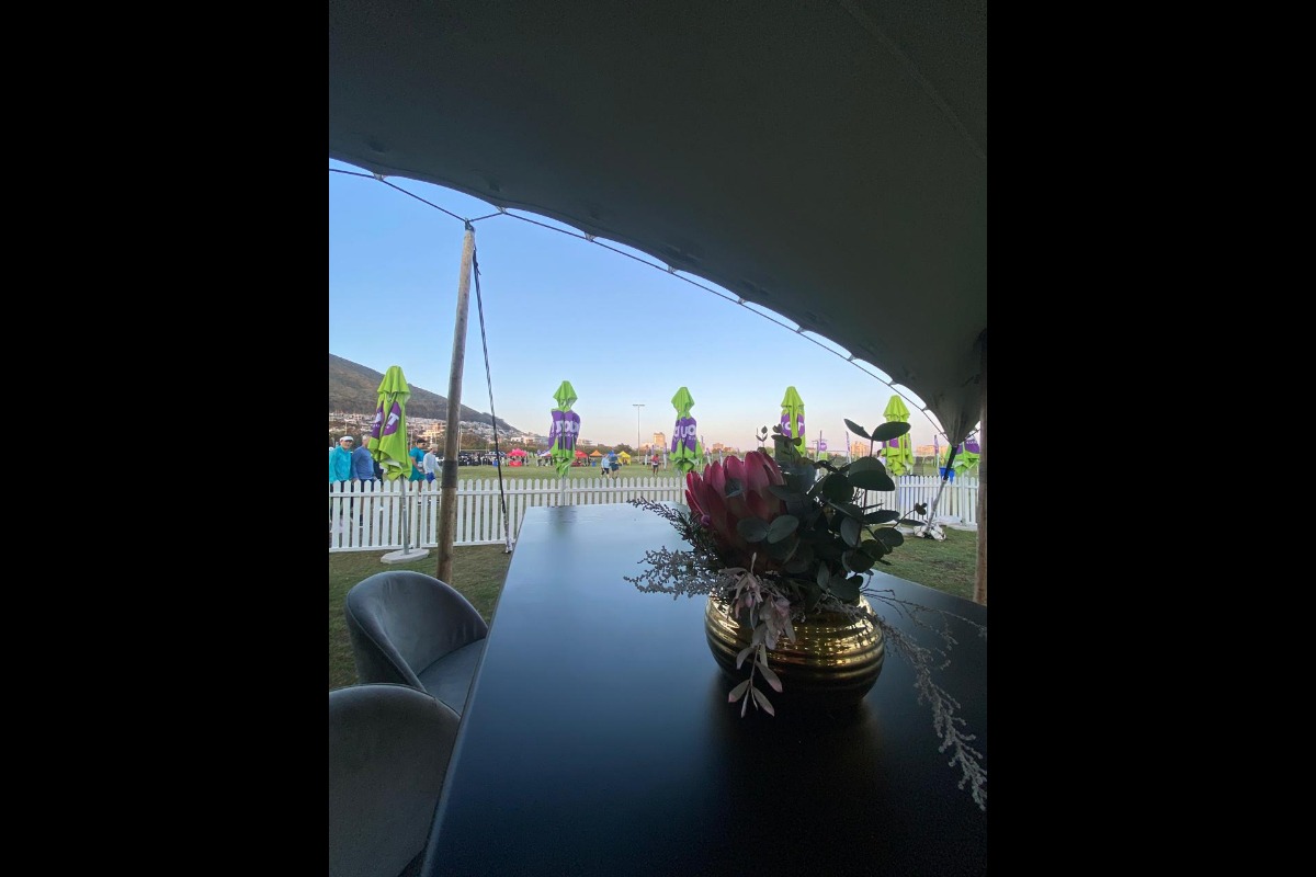 Black cocktail table with floral centrepiece at outdoor event – Animate-Co Styling