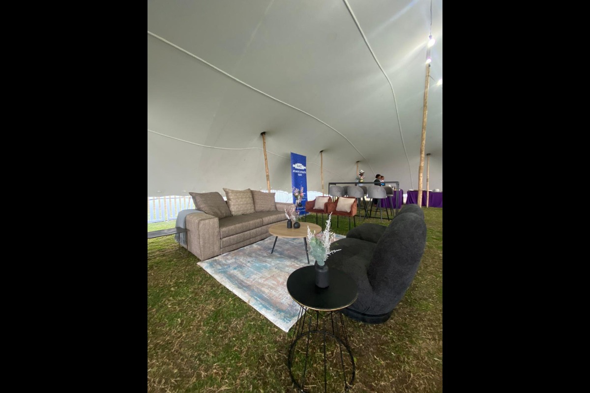 Cosy lounge furniture setup with rug and neutral tones at tented event
