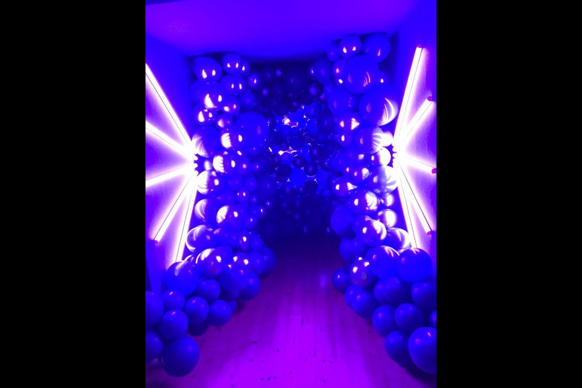 Neon-lit tunnel with balloons and florals