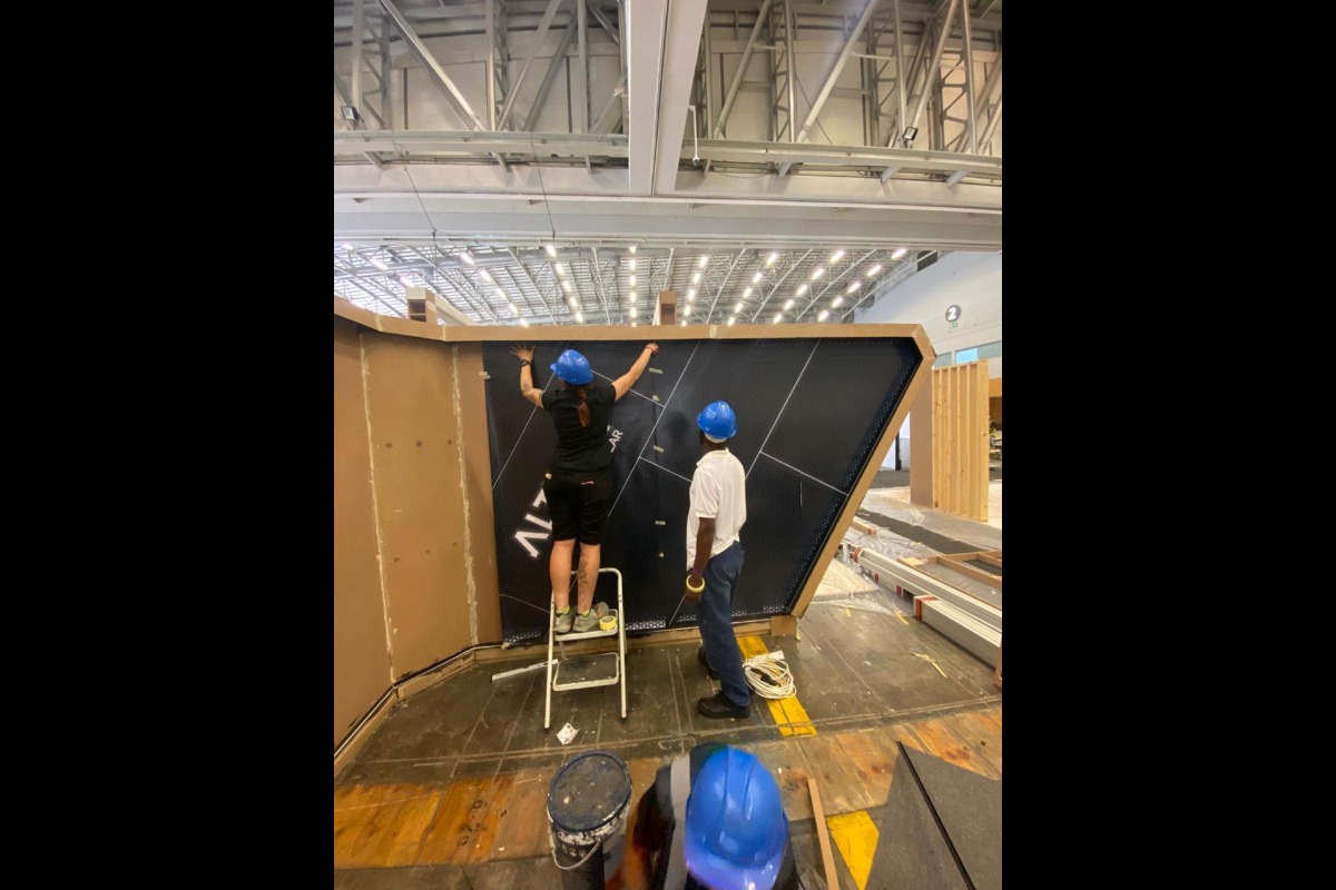 Expo stand team assembling branded exhibition wall