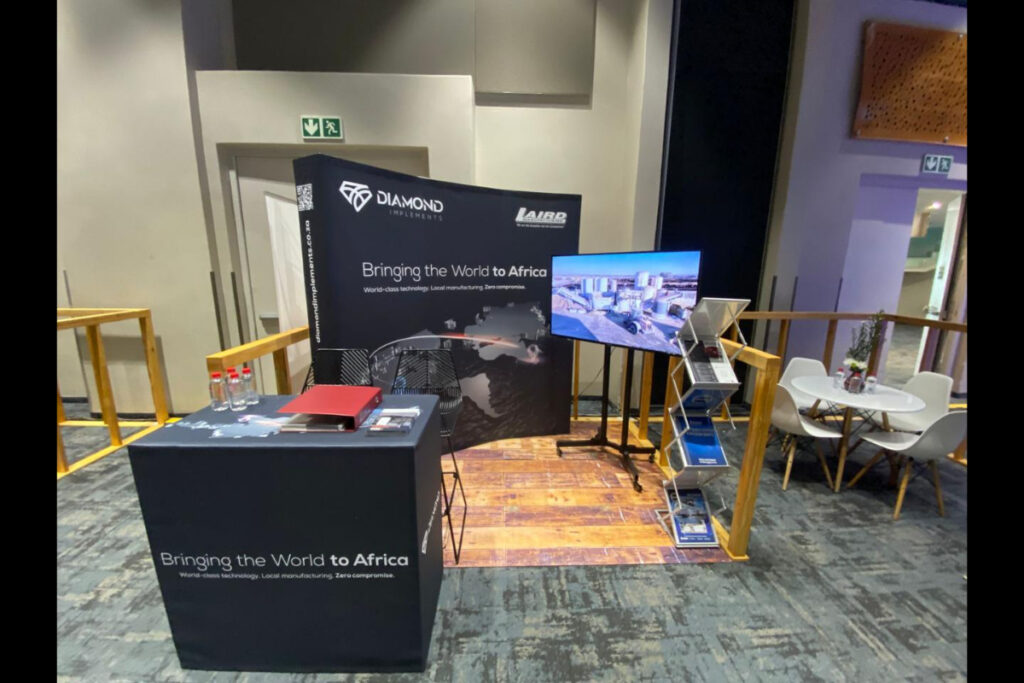 TV screen expo booth with brand graphics and table setup